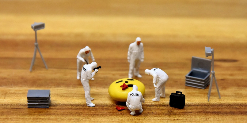 Kleine Plastikspielfiguren stellen forensische Szene an einem Tatort nach.